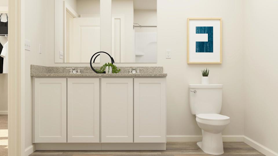 A bathroom with white cabinets.