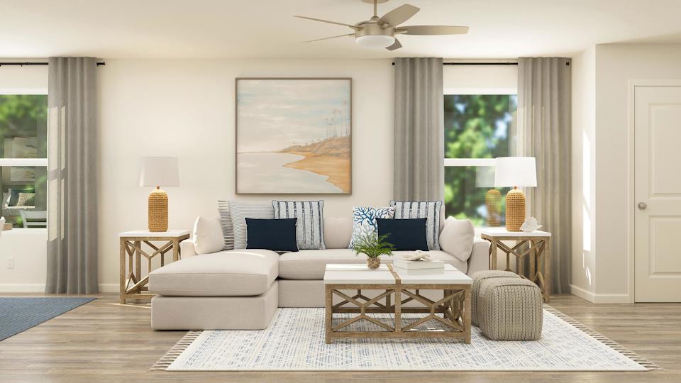 A living room with a couch and a fan.