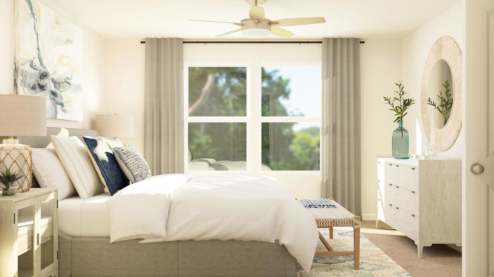 A living room with a white couch and a large window.