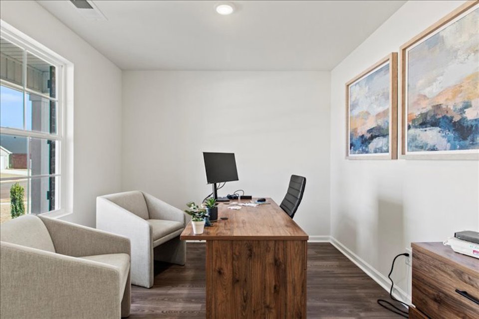 A room with a desk and chairs.