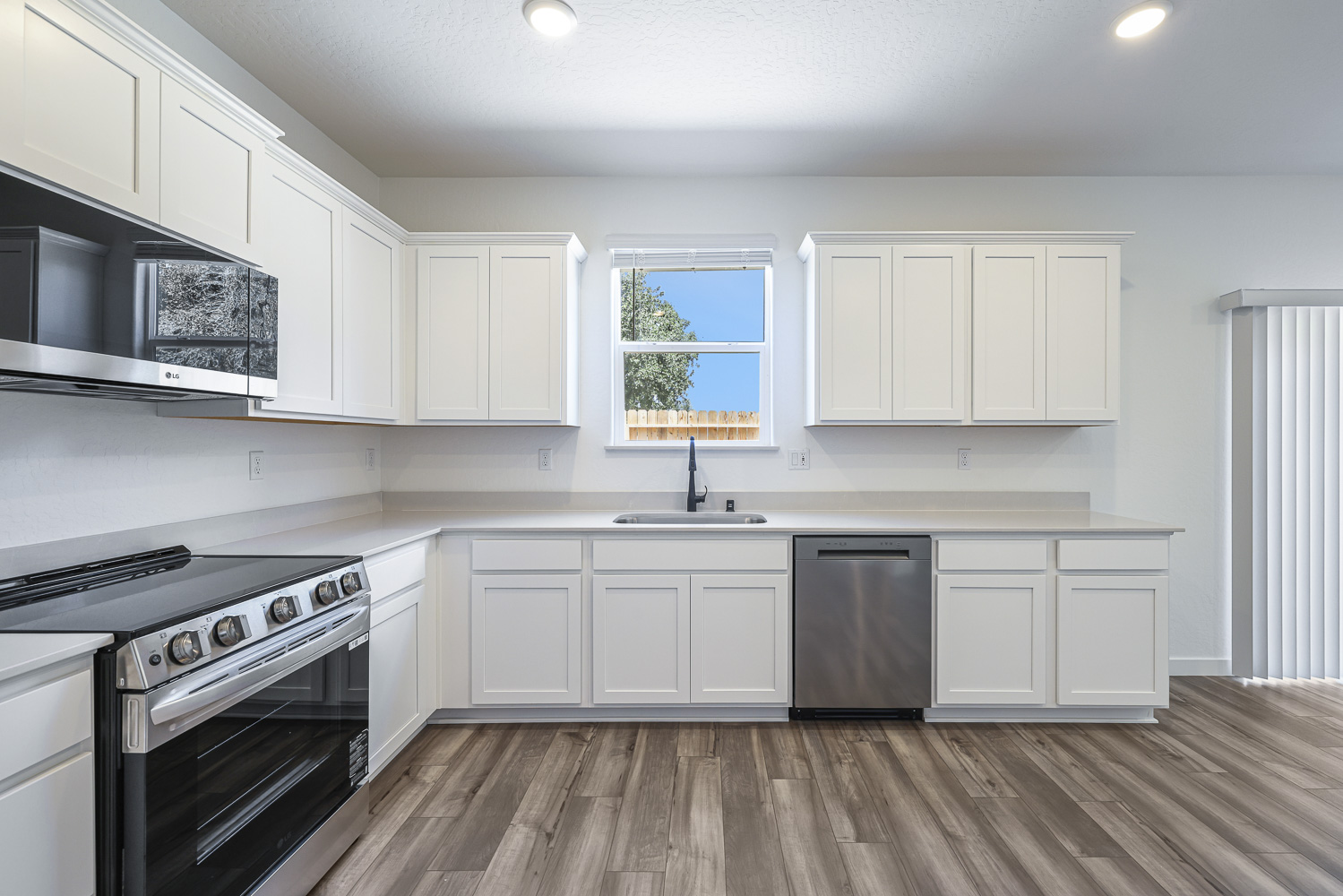 A kitchen with white cabinets.